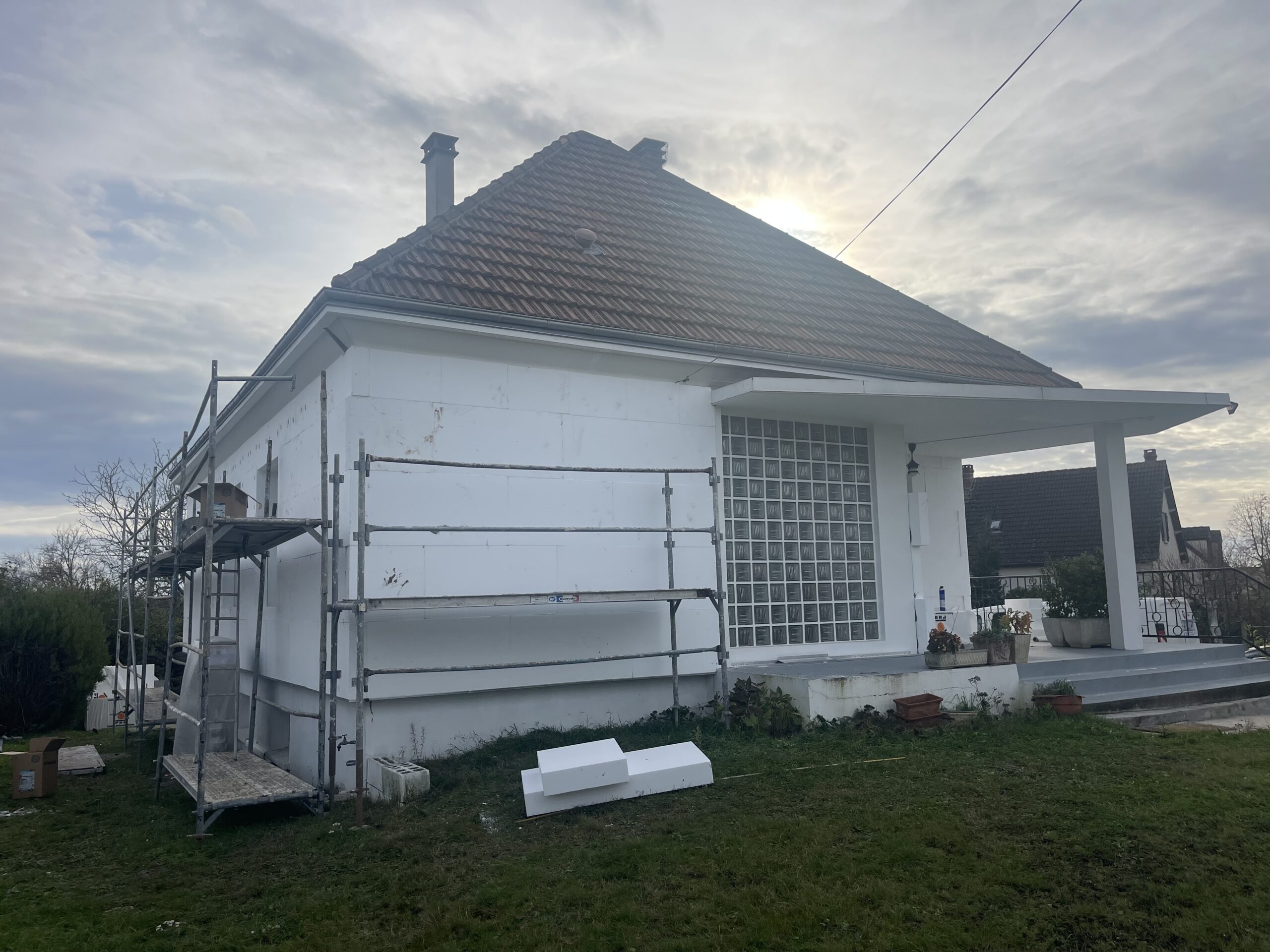 Travaux d’isolation thermique par l’extérieur (ITE) sur une maison individuelle en cours de rénovation.