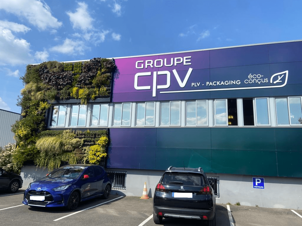 Façade CPV Plus rénovée – bardage rapporté végétal et signalétique Façade rénovée du siège CPV Plus avec logo, bardage végétalisé et panneaux colorés